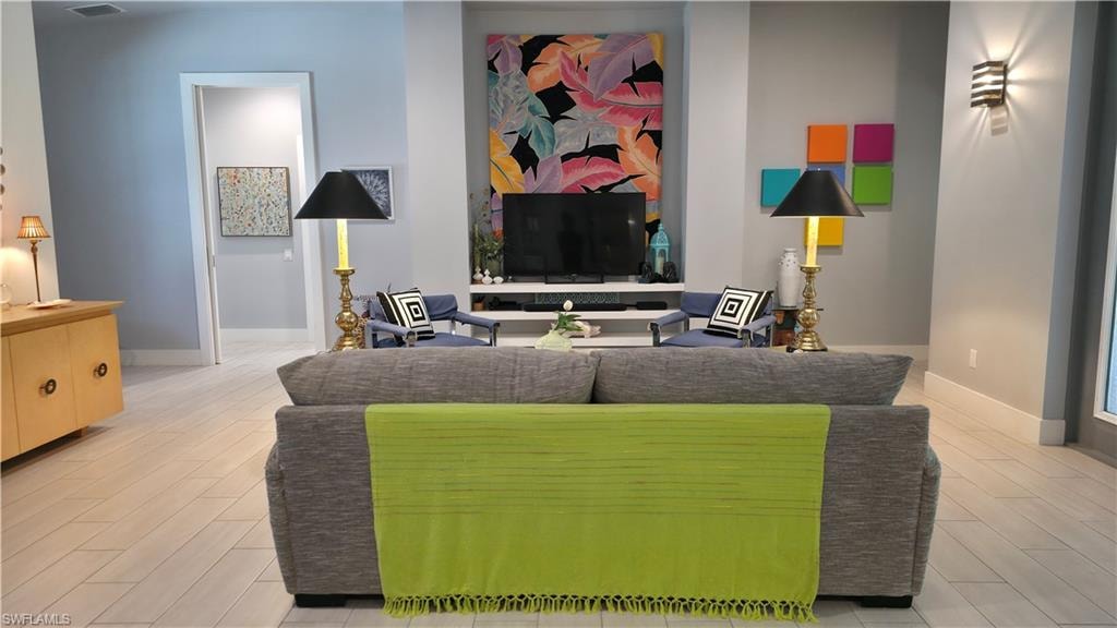 Spacious interior featuring light wood-finish flooring, recessed lighting, and a modern sconce