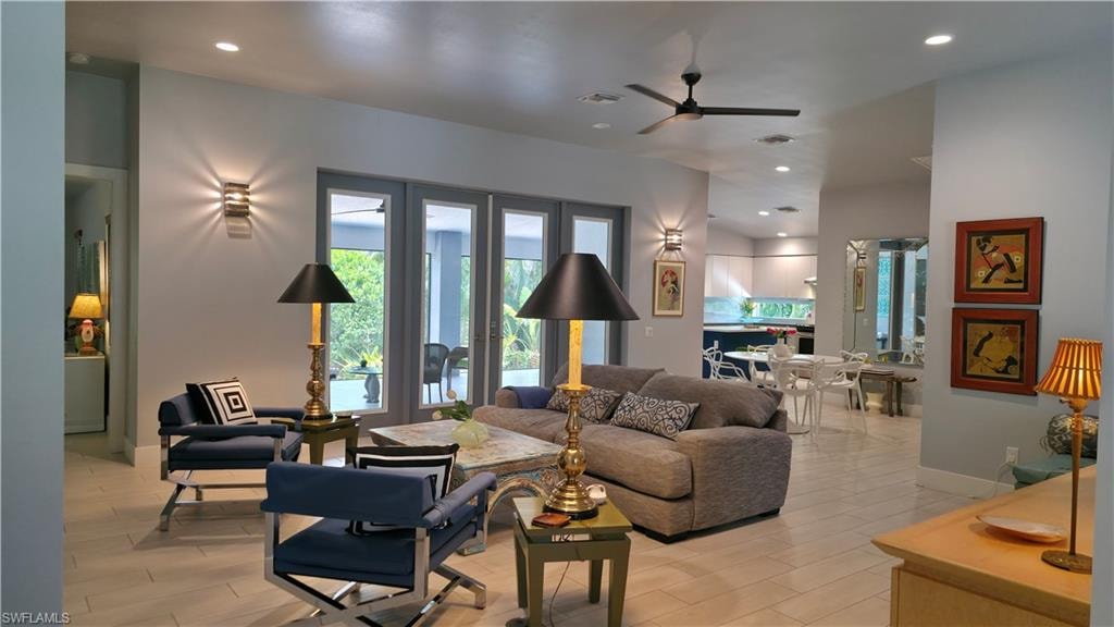 Living area featuring light tone flooring, a ceiling fan, and recessed lighting