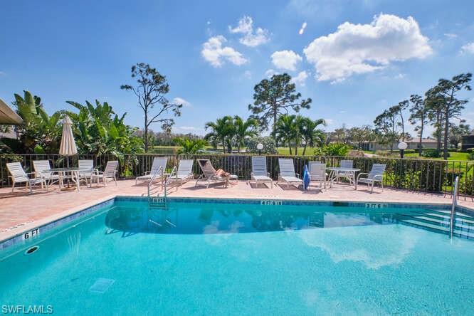 Community pool featuring a patio area and fence