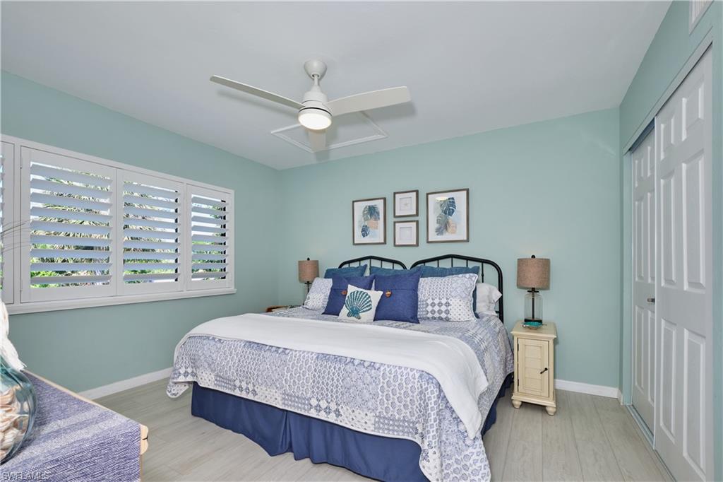 Guest bedroom featuring plantation shutters, lighted ceiling fan, plenty of closet space.