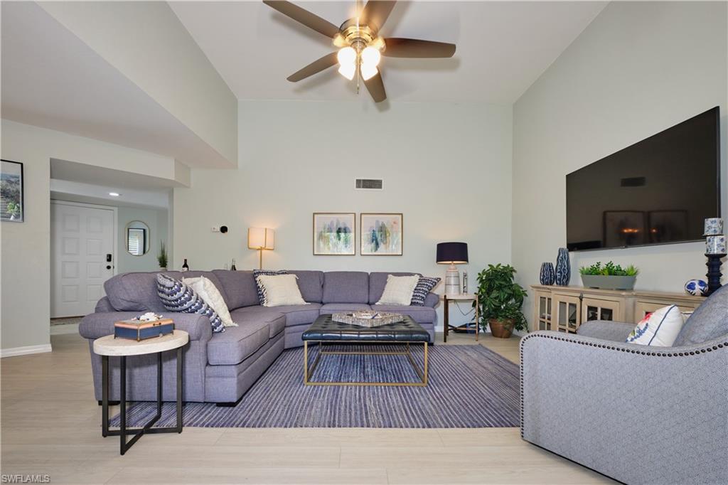 Living area featuring wood look LTV finished floors,  lighted ceiling fan, volume ceiling