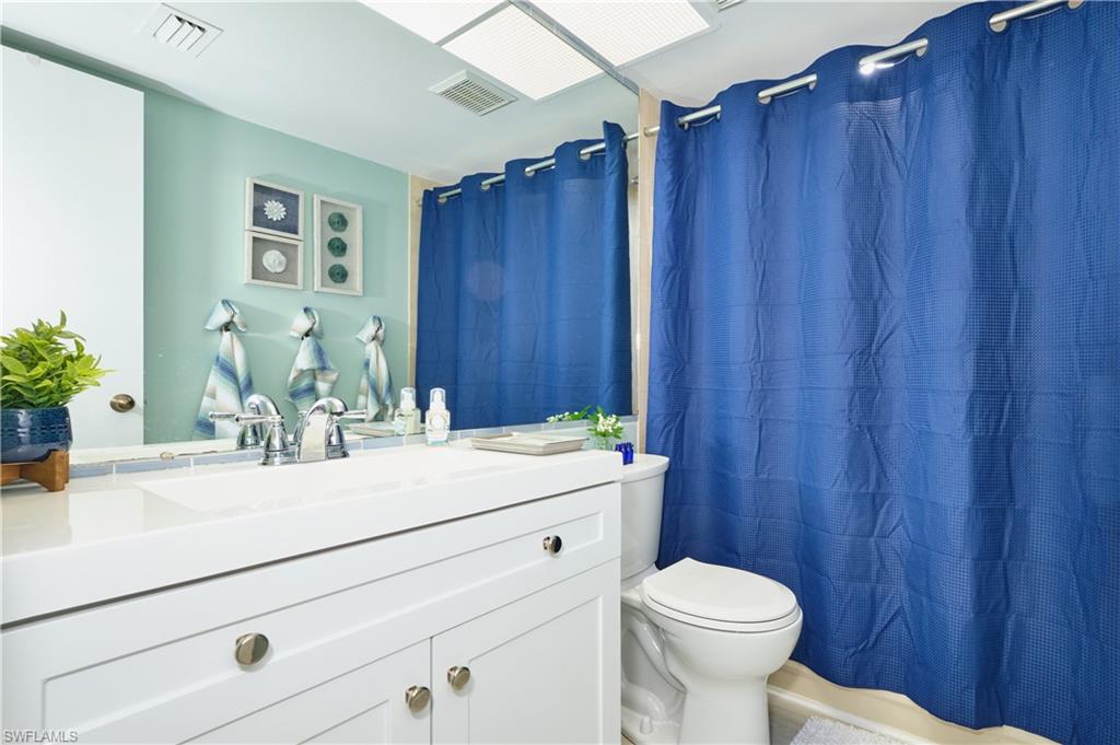 Guest bath features new vanity, tiled shower/tub combo.
