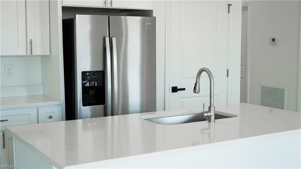 Kitchen island with an undermount sink and a brushed nickel gooseneck faucet