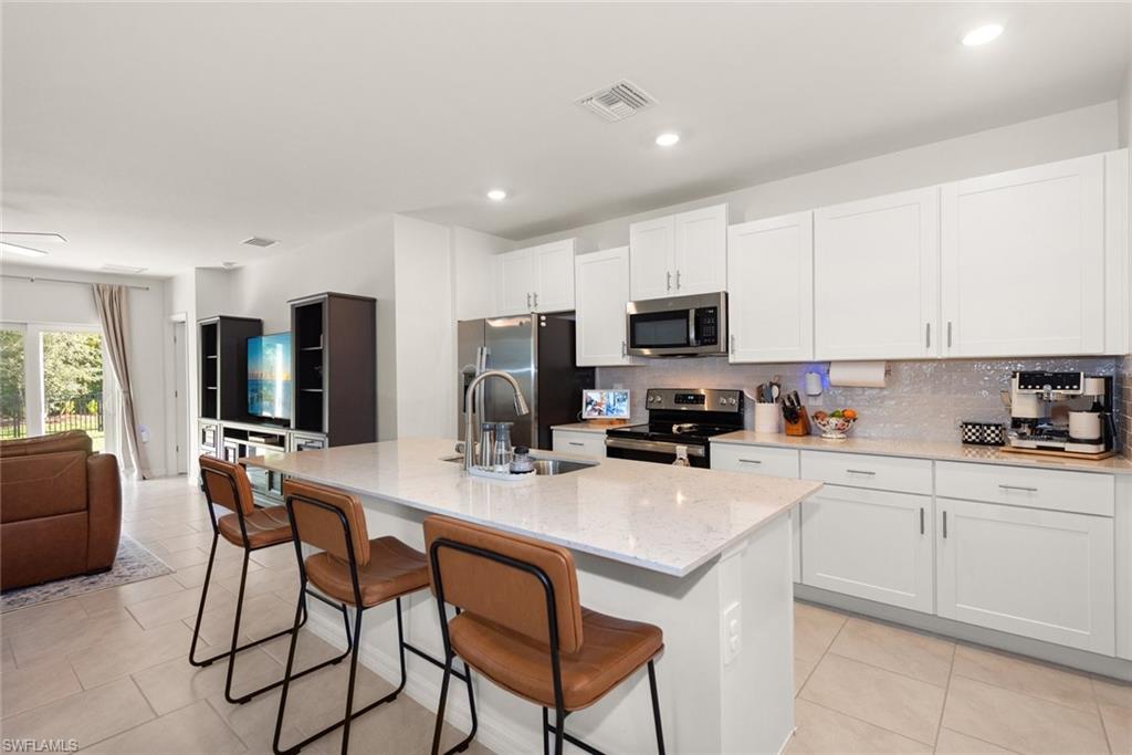 Kitchen features large island, lots of cabinet space and stainless steel appliances