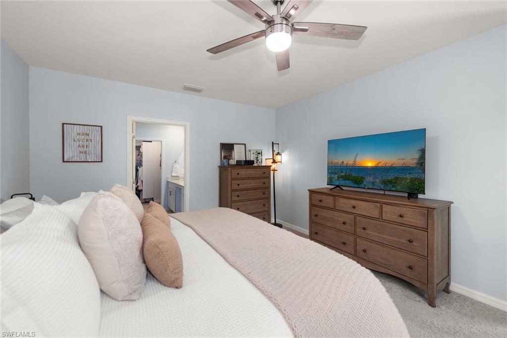 Spacious Primary bedroom features a large window overlooking the mature trees.