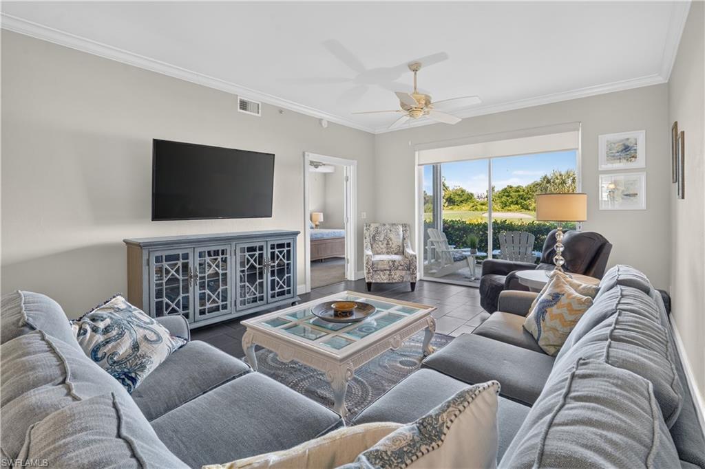 Living area featuring dark tile flooring and crown molding