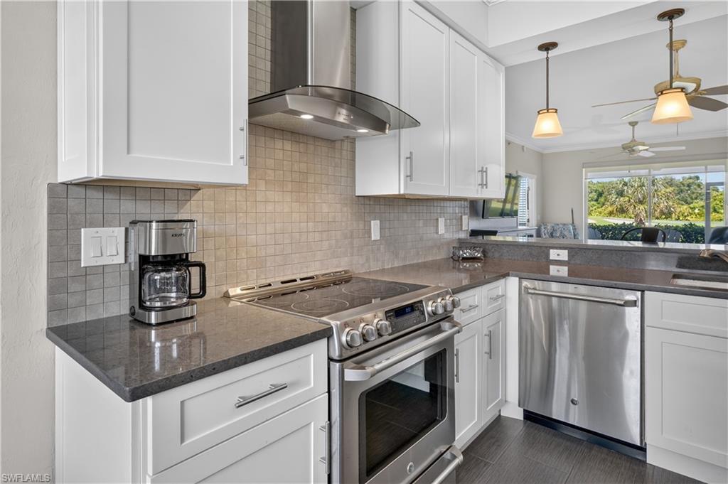 Contemporary kitchen featuring white cabinetry, dark countertops, and a tiled backsplash