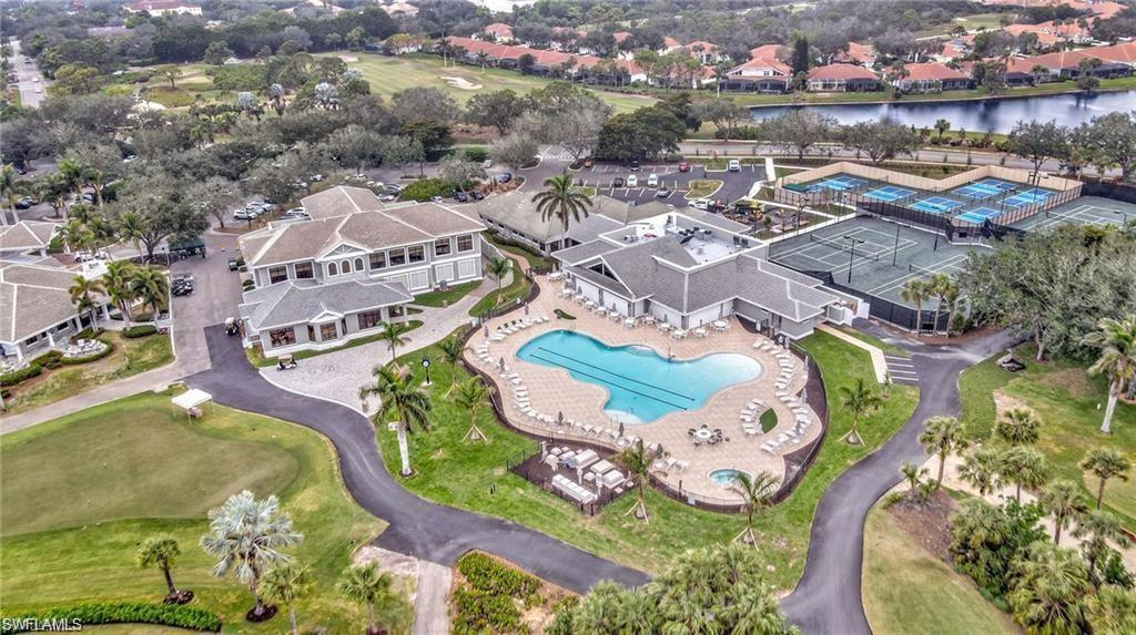 Expansive community grounds featuring a large swimming pool with surrounding lounge areas, multiple tennis courts, and a separate structure with additional courts