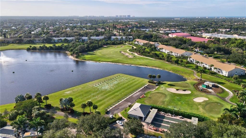 Expansive golf course and lake setting with tropical foliage and multiple residential buildings