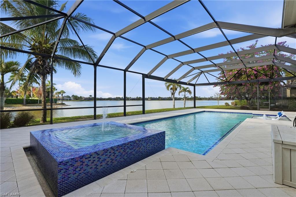 Screened outdoor living area featuring a rectangular pool and an integrated spa with a fountain