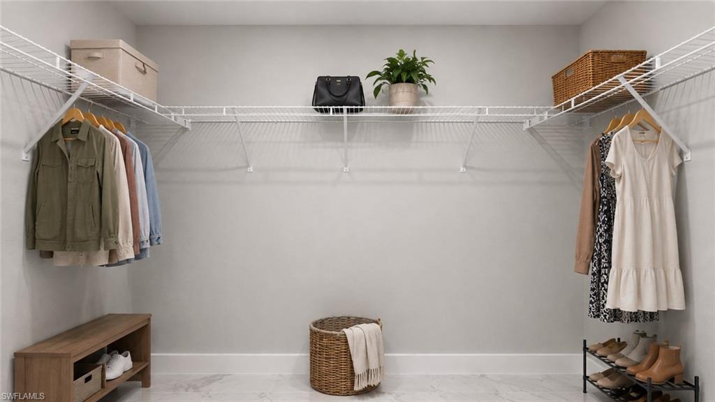 Spacious walk-in closet featuring dual clothing rods with multiple hanging sections, wire shelving systems with integrated storage baskets, wood-finish cabinetry with open shelving, and abundant natural light from recessed ceiling fixtures