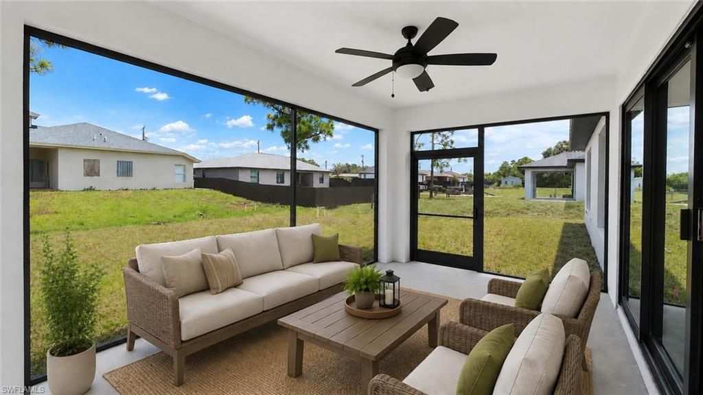 Screened outdoor living area featuring a ceiling fan, concrete flooring, and expansive views of the property's green space