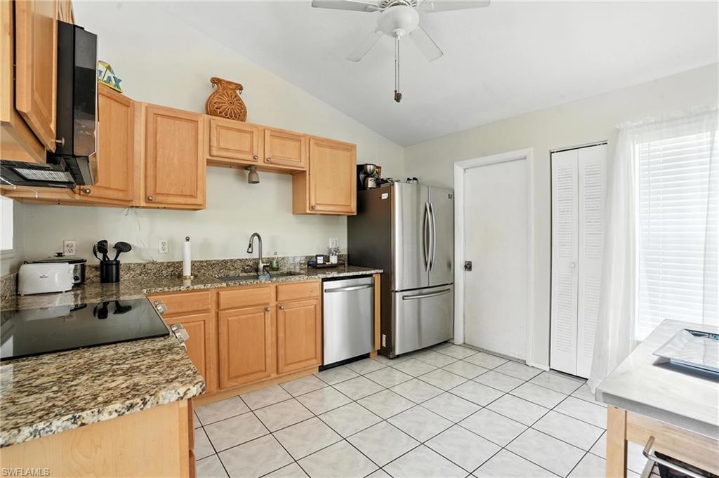 Kitchen featuring light wood cabinetry, granite-style countertops, and stainless steel appliances