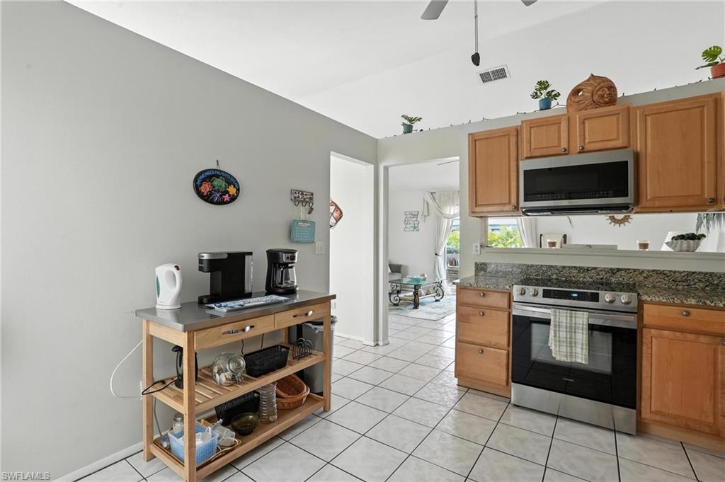 Kitchen featuring light wood-finish cabinetry, stainless steel appliances, and a tiled backsplash