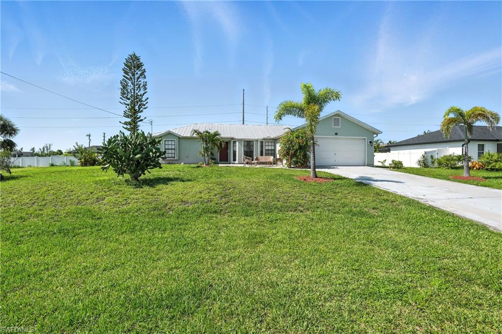 Single-story residence featuring a light green exterior, a front-facing garage, and a concrete driveway