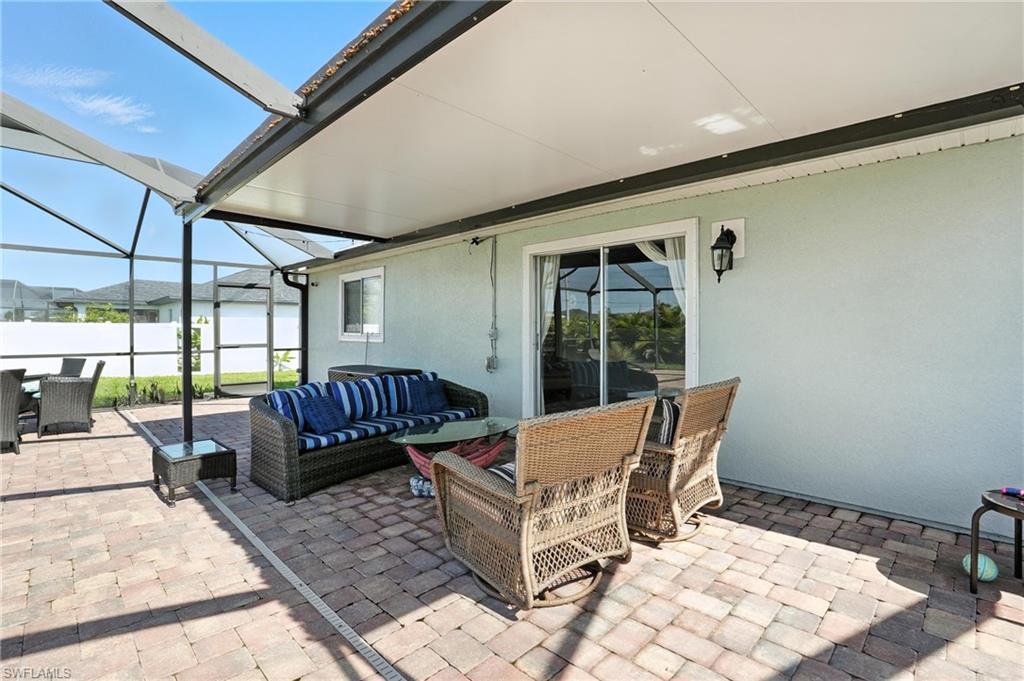 Screened patio featuring paver flooring, a solid roof covering, and direct access through sliding glass doors