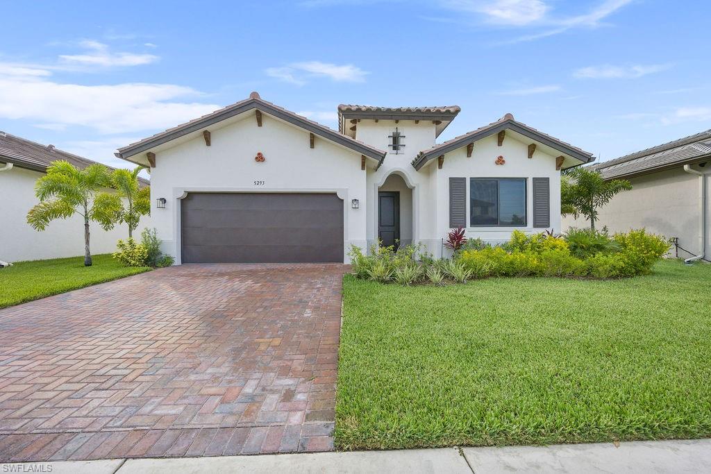 Mediterranean / spanish home featuring a garage and a front lawn