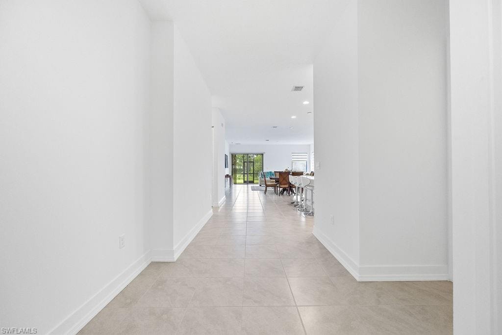 Corridor featuring light tile floors