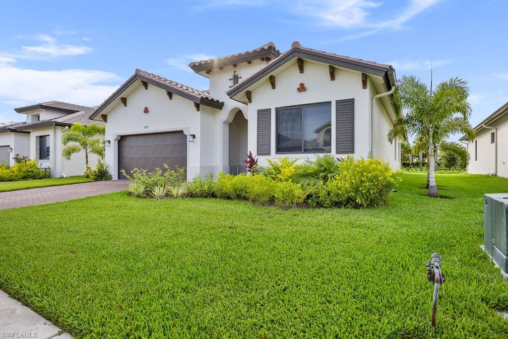 Mediterranean / spanish home featuring a garage and a front yard