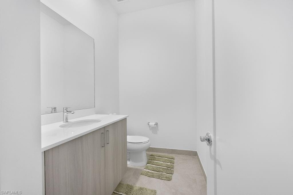 Bathroom with tile floors, vanity, and toilet
