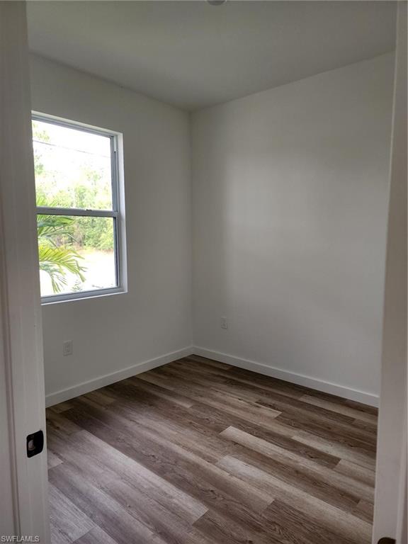 Unfurnished room featuring wood finished floors and baseboards
