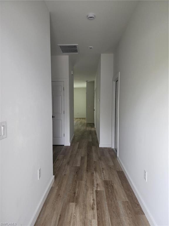 Hallway featuring wood finished floors and baseboards