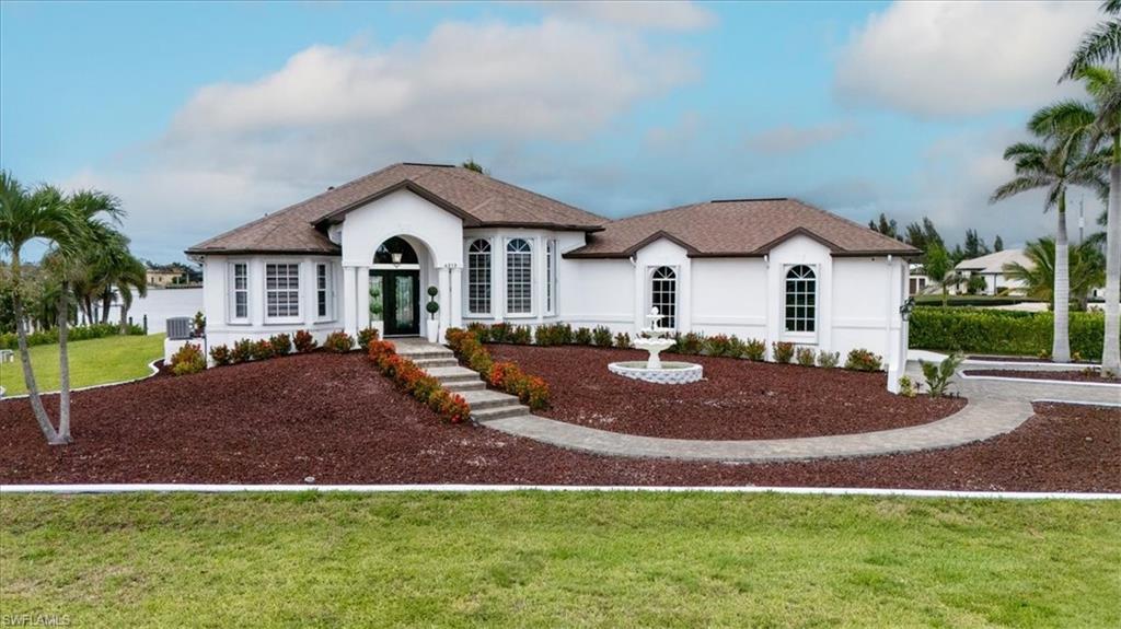 View of front facade featuring stucco siding, a front yard, and french doors
