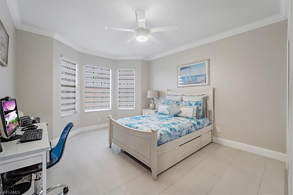 Bedroom featuring a desk, crown molding, a ceiling fan, and light tile patterned floors