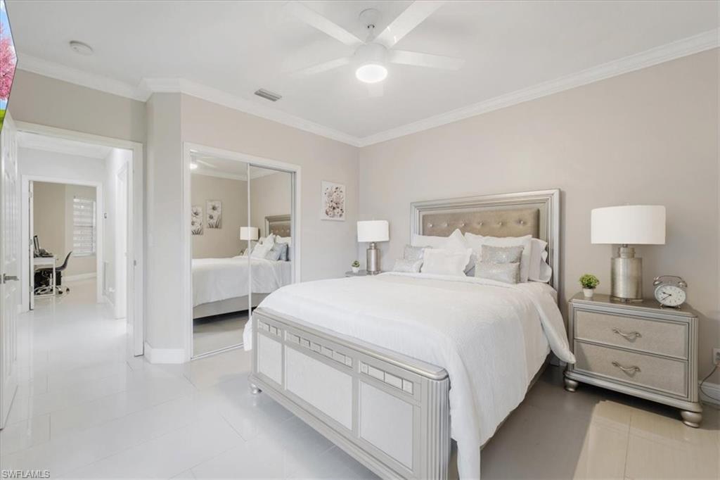 Bedroom with crown molding, a closet, ceiling fan, and light tile patterned flooring