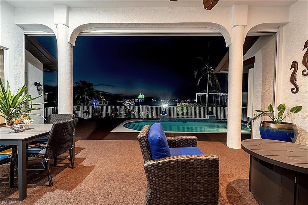Pool at night featuring a patio area and outdoor dining space