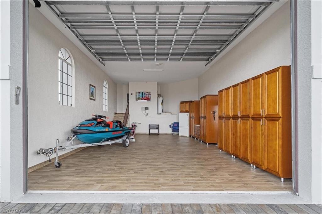 Garage with a textured wall and freestanding refrigerator