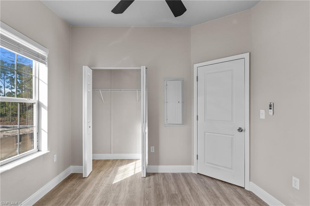 Unfurnished bedroom with a closet, light wood-style floors, and a ceiling fan