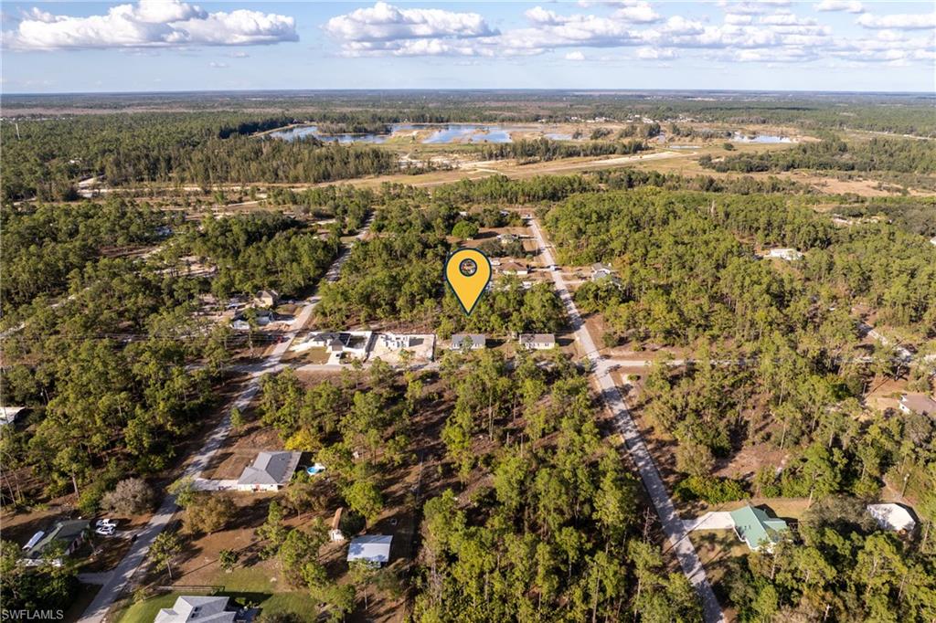 View of property location featuring a heavily wooded area and a nearby body of water