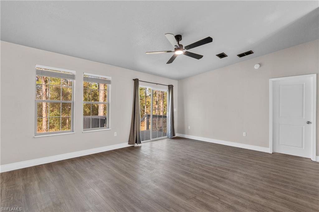 Empty room featuring dark wood-style floors and ceiling fan
