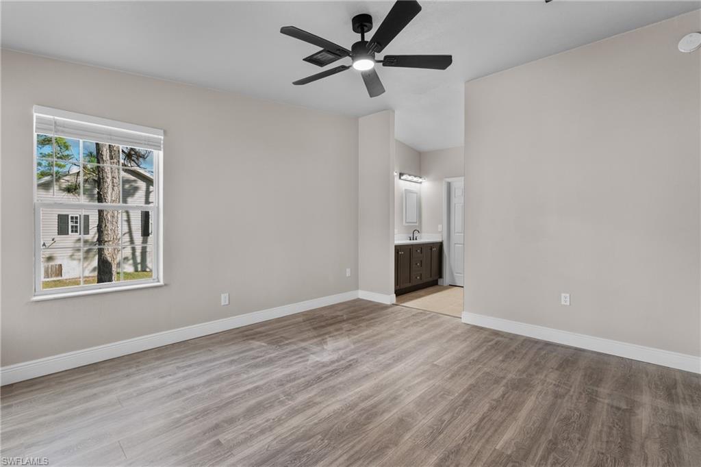 Unfurnished bedroom featuring light wood-style floors, a ceiling fan, and ensuite bathroom