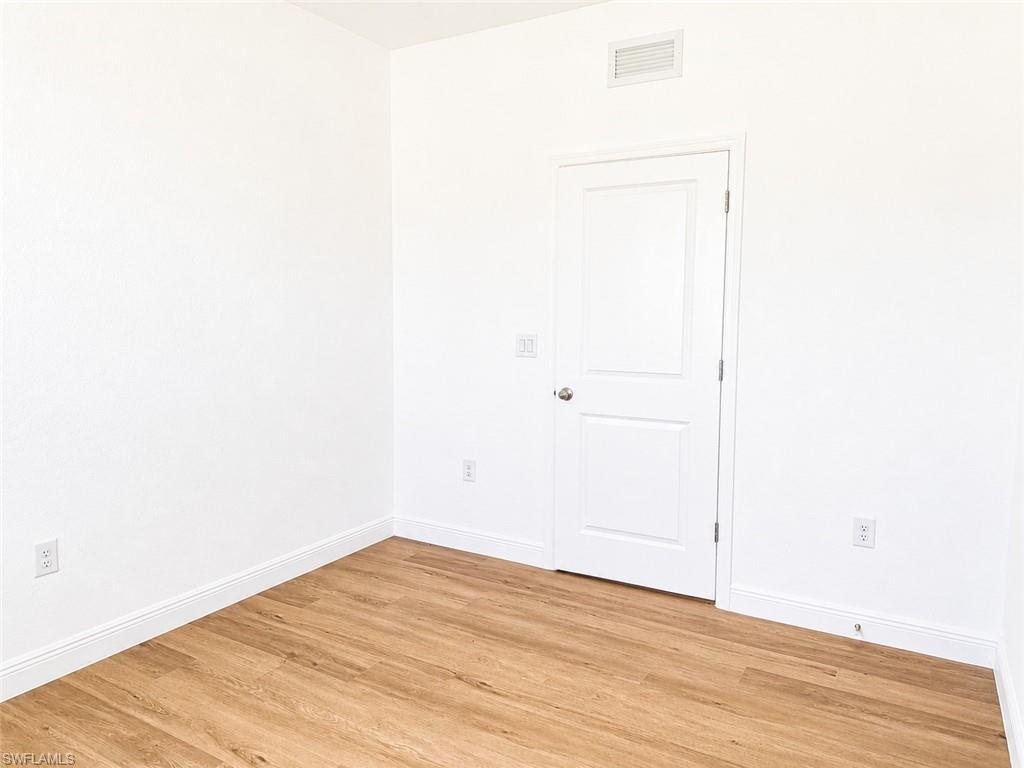Light wood-finish flooring complements crisp white walls and baseboards