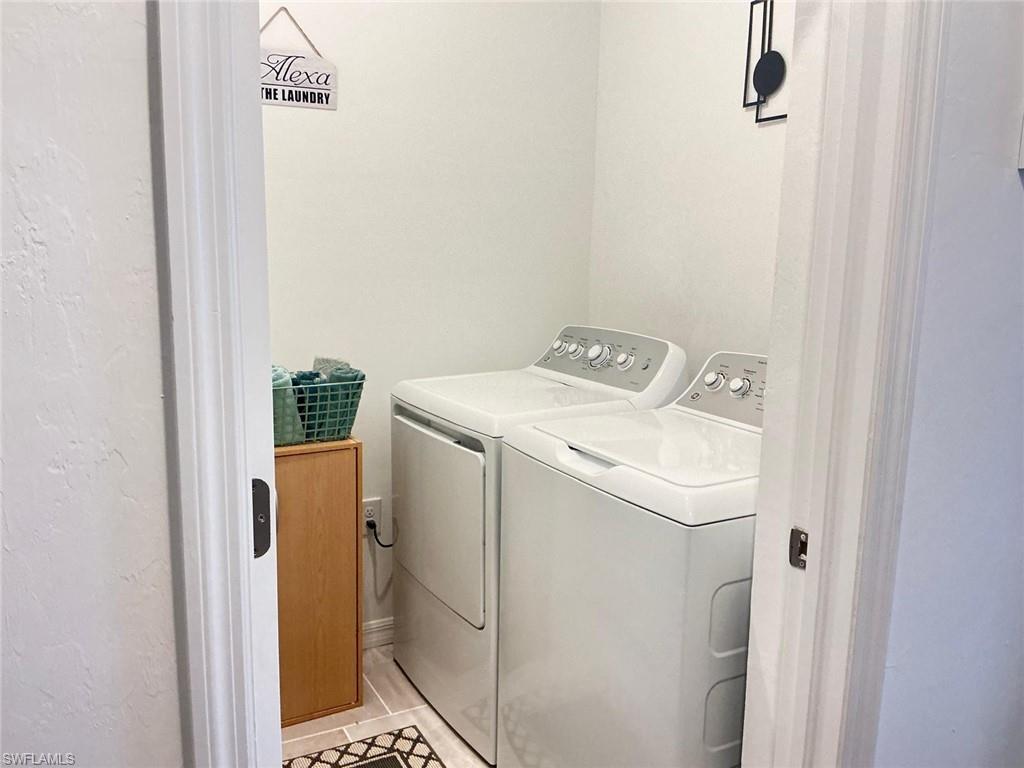 Dedicated laundry area featuring a tile floor and light-toned walls
