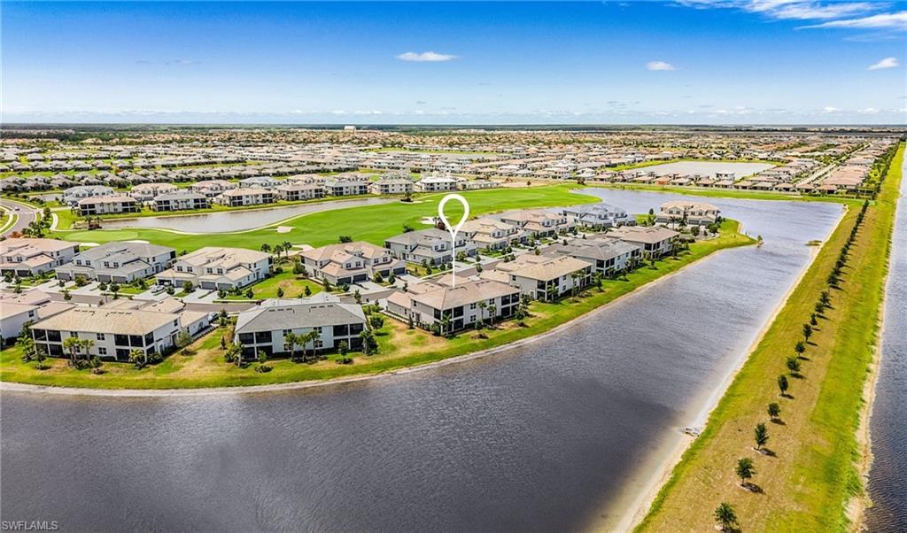 Aerial view of a residential community featuring waterways, green spaces, and a golf course