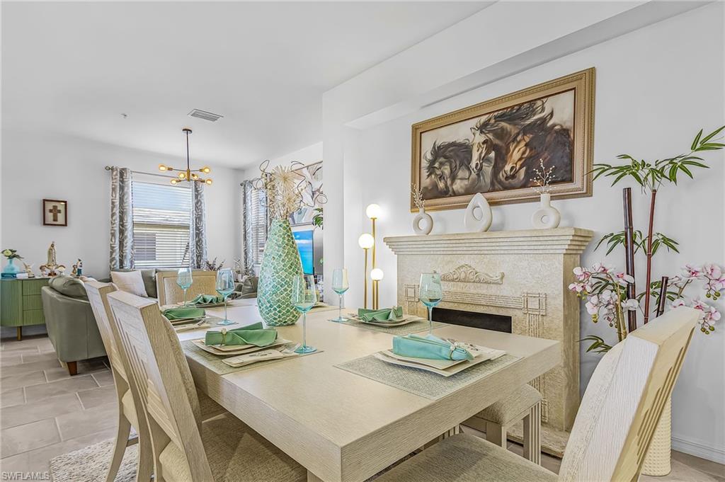 Dining area featuring a decorative mantel, neutral wall tones, and tiled flooring