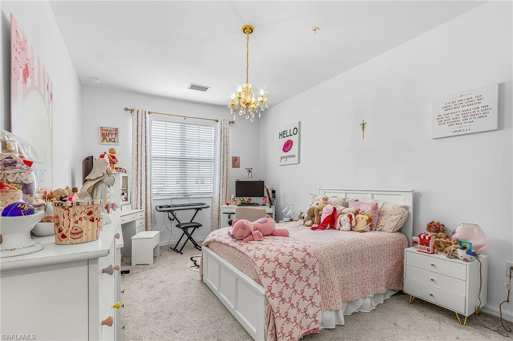 Spacious room featuring neutral carpeting, a large window with blinds, and white walls