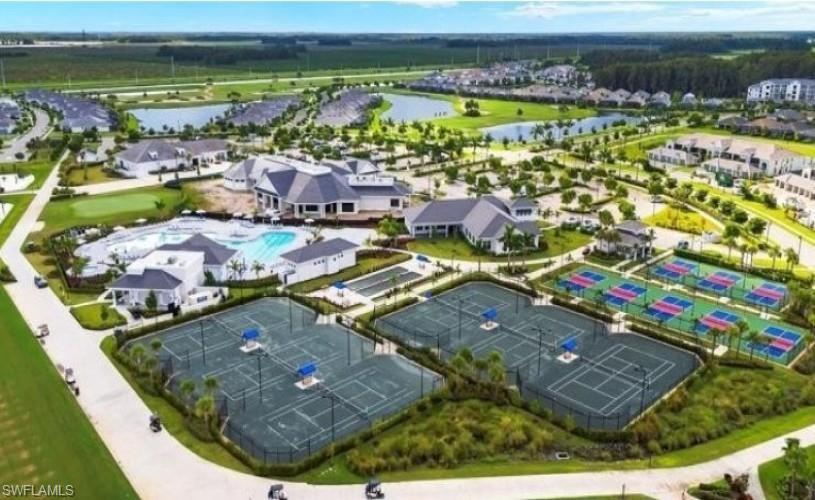 Expansive community amenities including multiple tennis courts, pickleball courts, and a resort-style swimming pool area with a clubhouse