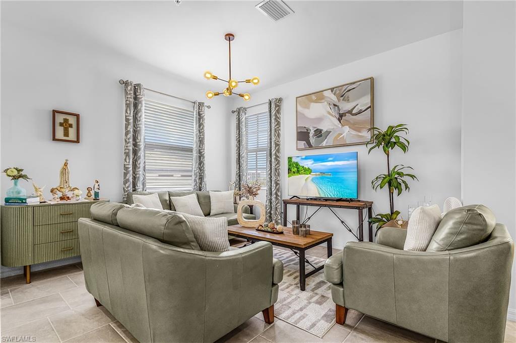 Bright living area featuring light-toned tile flooring and white walls