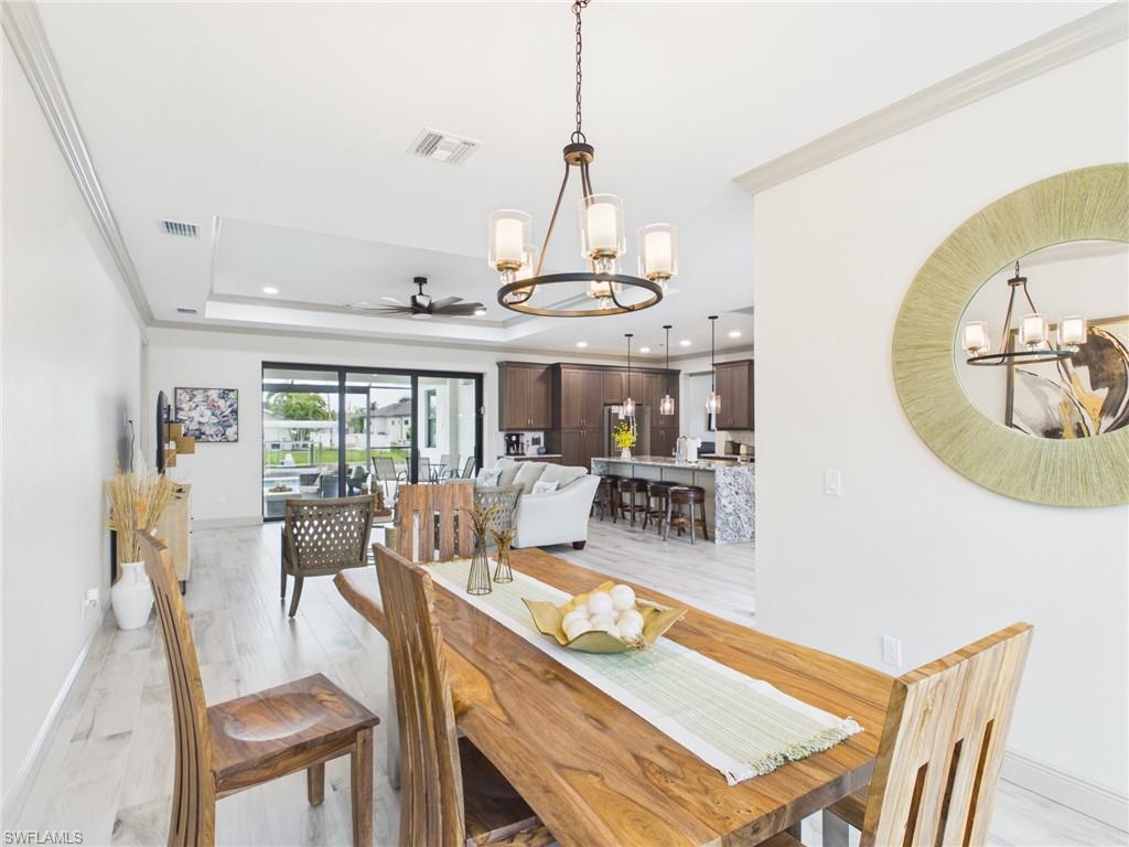 Spacious room with tray ceiling, contemporary ceiling fan, and wood-finish flooring