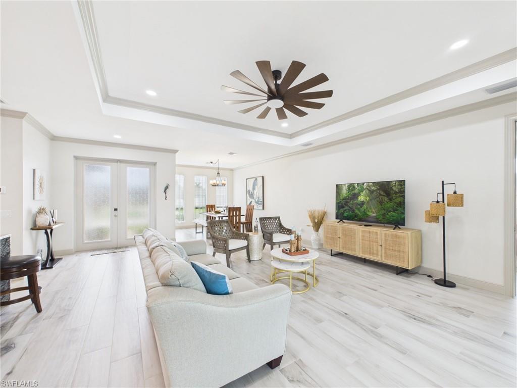 Modern kitchen featuring granite countertops, wood-finish cabinetry, a stainless steel range hood, and pendant lighting fixtures