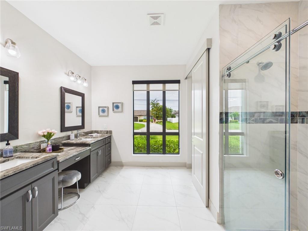 Bathroom featuring a glass-enclosed shower with decorative vertical tile inlay, shower bench, and recessed lighting