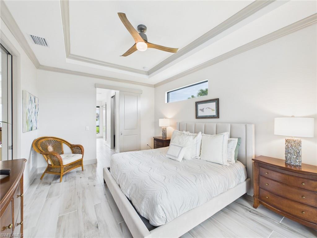 Light-toned wood-finish flooring complements the crisp white walls in this space featuring a modern ceiling fan with integrated lighting