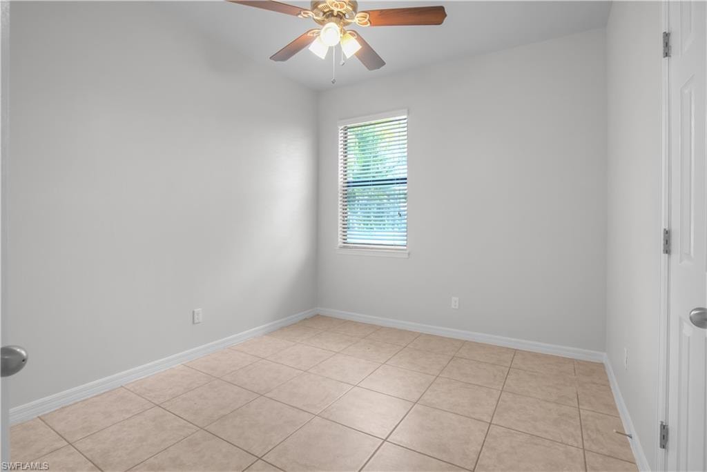 Neutral-toned room featuring tile flooring, a window with horizontal blinds, and a ceiling fan with integrated lighting