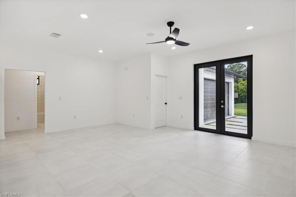 Empty room featuring french doors and ceiling fan