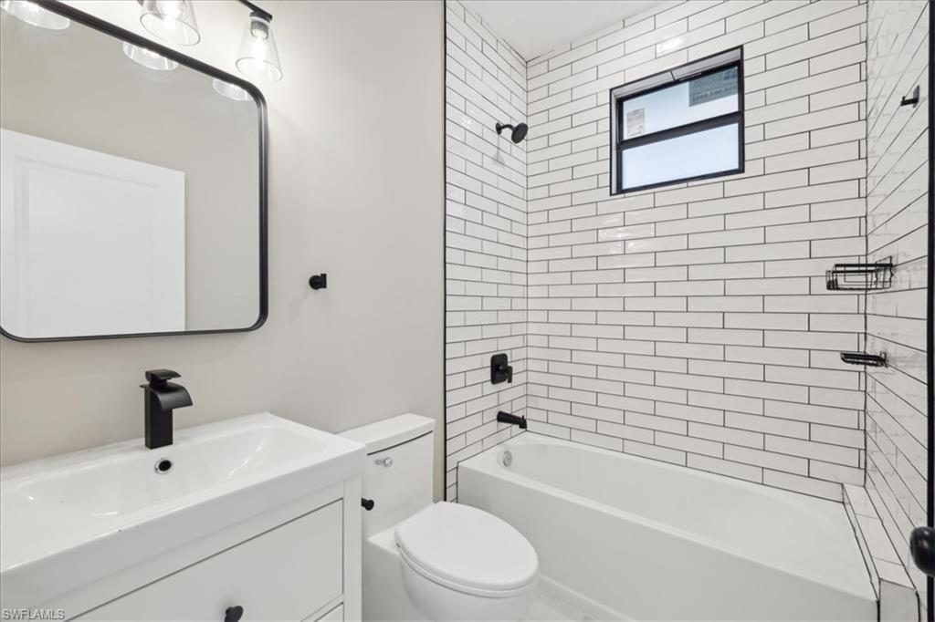 Full bathroom featuring vanity, toilet, and tiled shower / bath combo