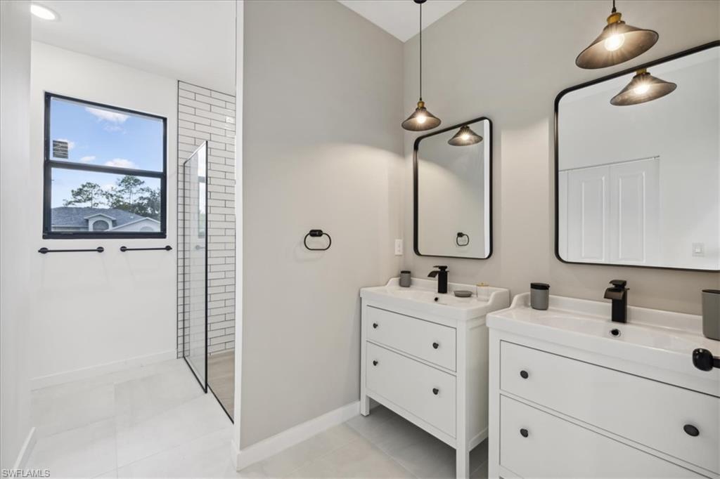 Bathroom featuring vanity, a shower, and tile patterned flooring